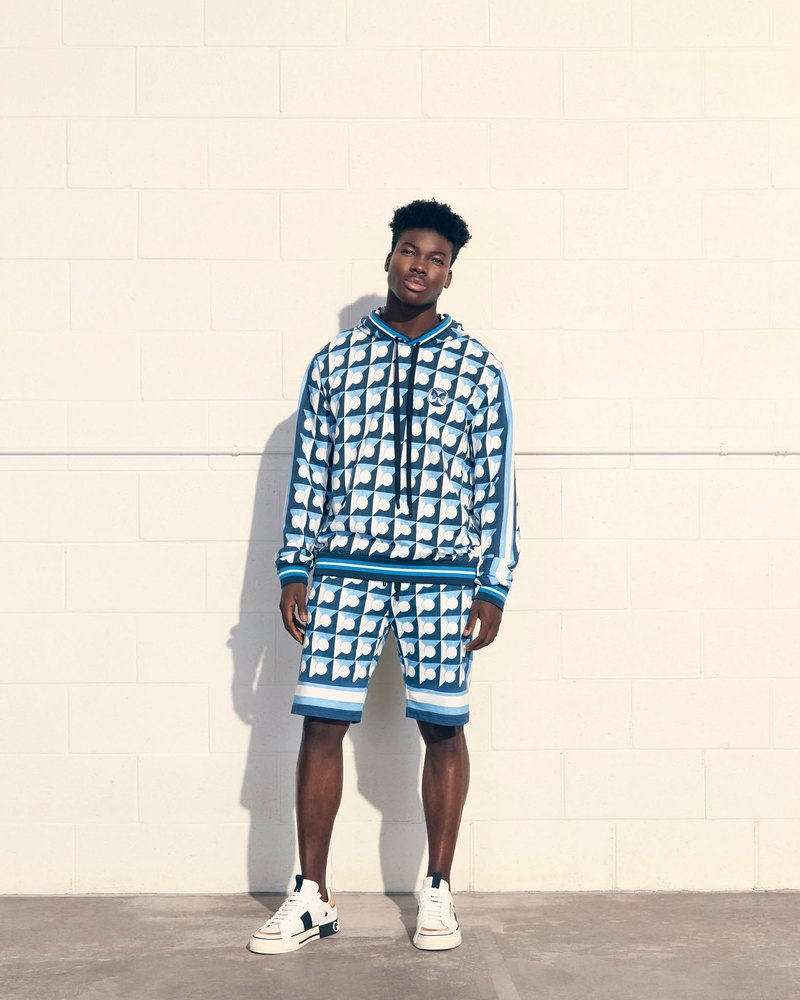 Designer sportswear styled against a white wall, campaign photography